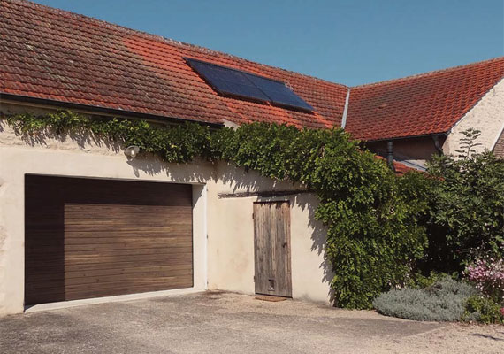 Porte sectionnelle, habillage recyclé avec le parement de la porte battante d'origine.